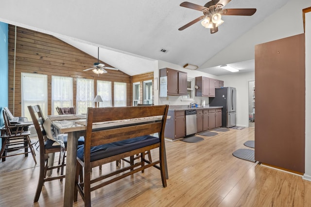 171 N Main St, Ridgeville, SC 29472 - dining room featuring a ceiling fan, light wood-style flooring, wood walls, and high vaulted ceiling