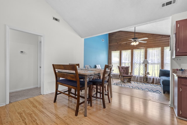 171 N Main St, Ridgeville, SC 29472 - dining area with light wood-type flooring, a ceiling fan, high vaulted ceiling, and wooden walls