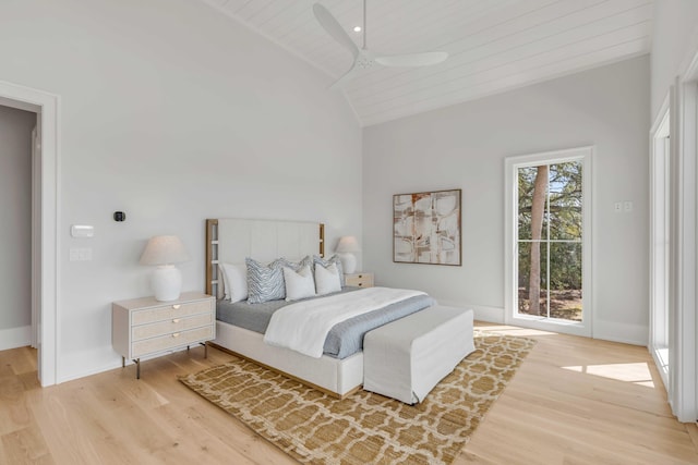 bedroom featuring lofted ceiling, light wood-style floors, baseboards, and a ceiling fan