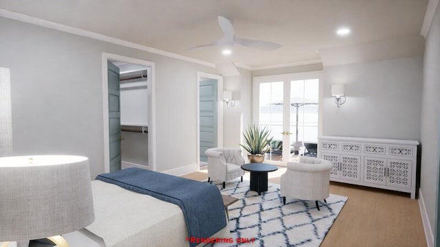 bedroom featuring baseboards, wood finished floors, ensuite bathroom, a walk in closet, and crown molding