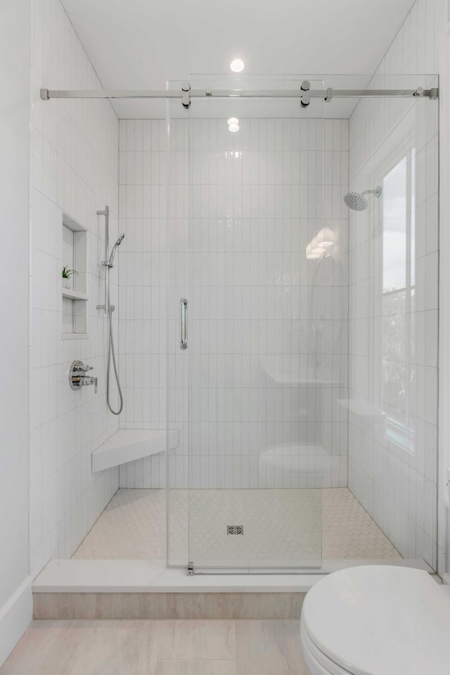 full bath with toilet and a stall shower