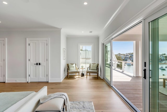 sitting room featuring light wood finished floors, baseboards, ornamental molding, and recessed lighting