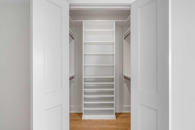 walk in closet with light wood-style flooring