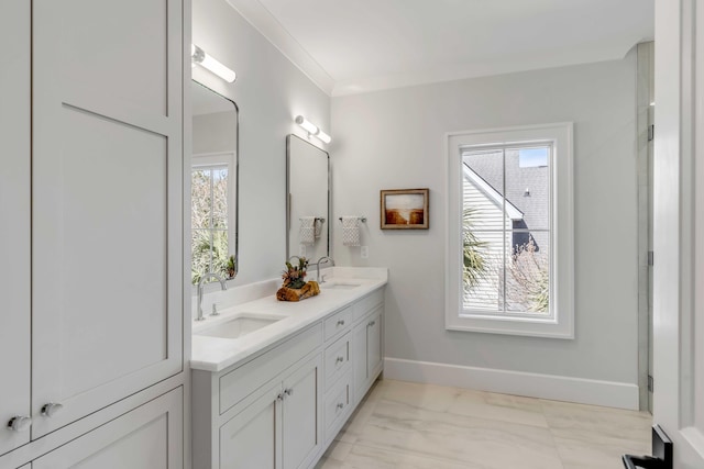 bathroom with marble finish floor, a sink, baseboards, and double vanity