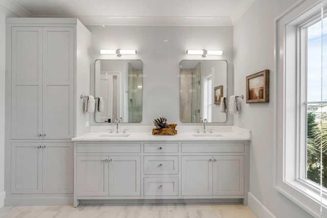 full bathroom featuring double vanity, a sink, and a shower with door