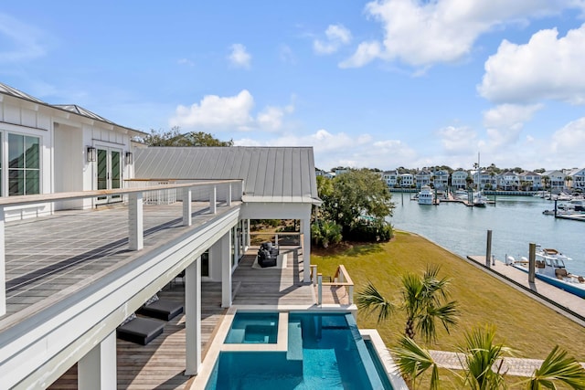 dock area with a water view, an outdoor pool, and a lawn