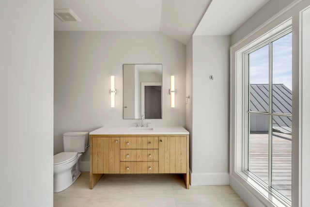 bathroom featuring baseboards, visible vents, toilet, vaulted ceiling, and vanity