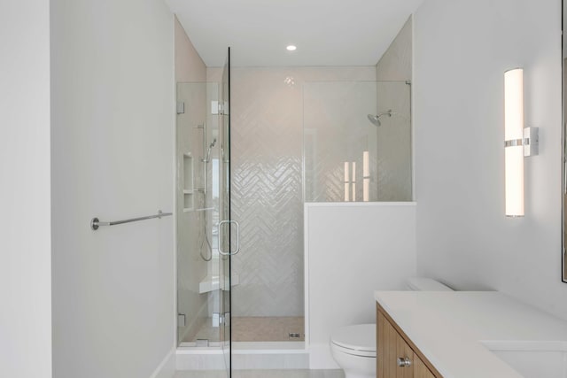 bathroom with toilet, a shower stall, and vanity