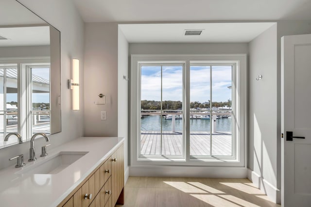 interior space featuring a water view, visible vents, and a sink