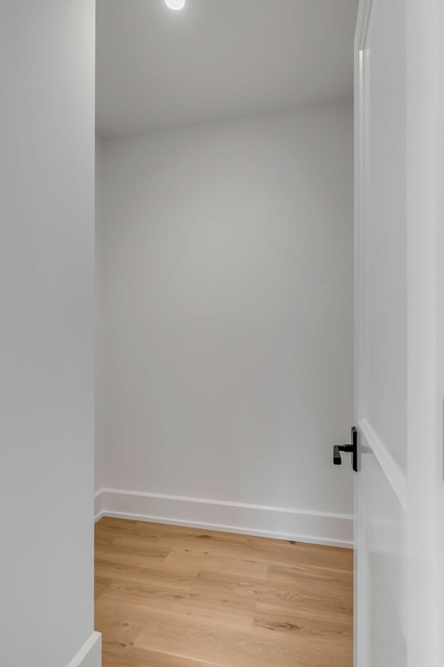 spare room featuring light wood-style floors and baseboards