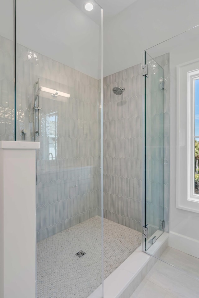 bathroom featuring a walk in shower, baseboards, and tile patterned floors