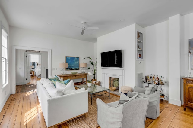 living room with ceiling fan and light hardwood / wood-style flooring