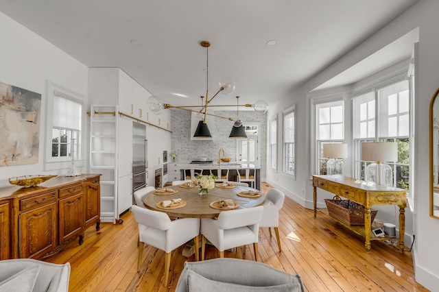 dining room with light hardwood / wood-style floors and a notable chandelier