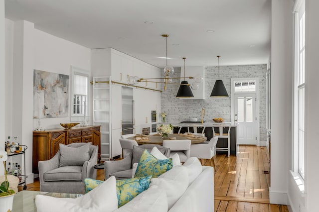 living room with light hardwood / wood-style floors and a notable chandelier