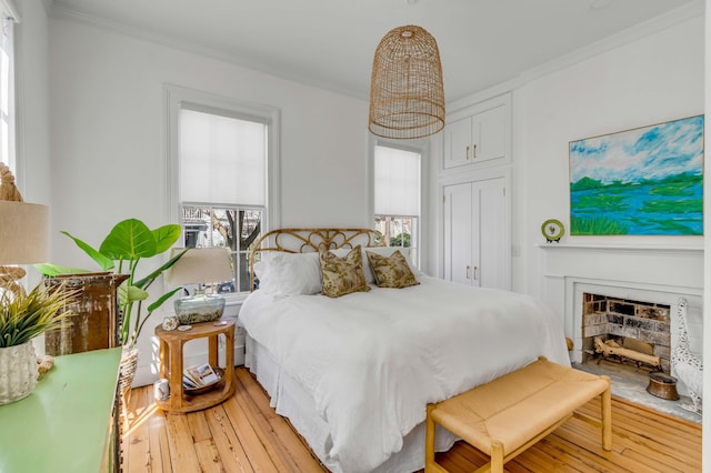 bedroom with multiple windows, ornamental molding, and light hardwood / wood-style floors