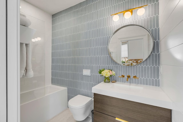 full bathroom featuring toilet, bathing tub / shower combination, tasteful backsplash, tile walls, and vanity