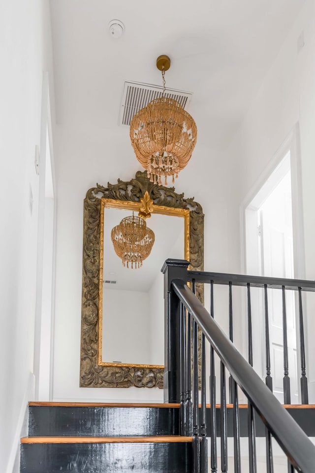 stairs featuring an inviting chandelier