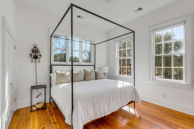 bedroom featuring multiple windows and hardwood / wood-style floors