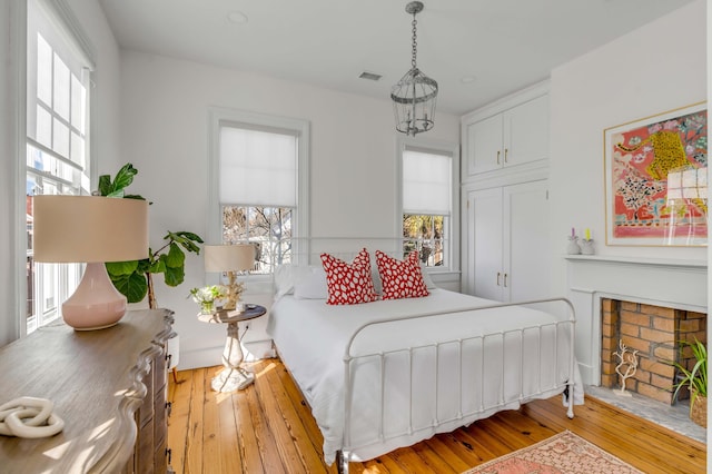 bedroom featuring a fireplace and light wood-type flooring