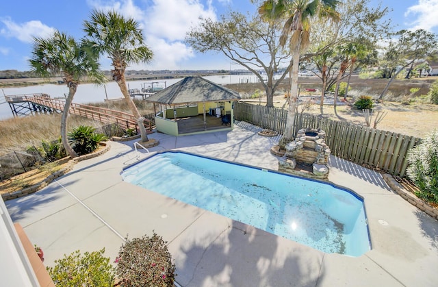 view of pool with a fenced in pool, a fenced backyard, a gazebo, a water view, and a patio area