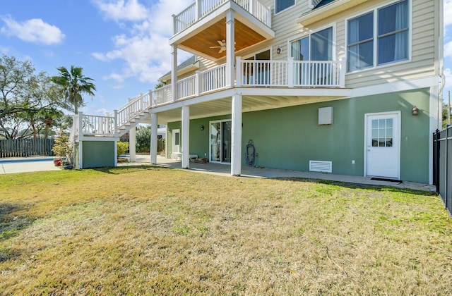 rear view of house with a lawn, stairway, crawl space, a fenced in pool, and a patio area