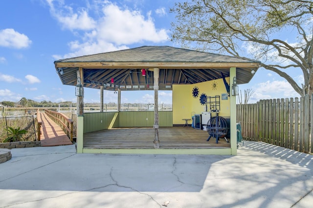 view of patio featuring a deck, a gazebo, and fence