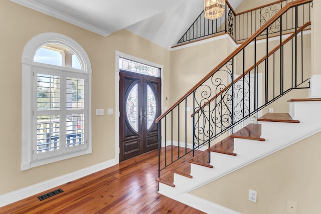 foyer with visible vents, baseboards, a high ceiling, french doors, and wood-type flooring