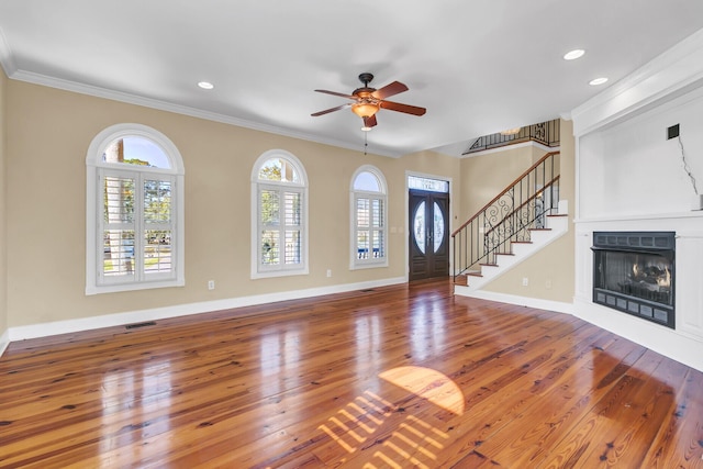 entrance foyer with visible vents, ornamental molding, hardwood / wood-style flooring, stairway, and a fireplace