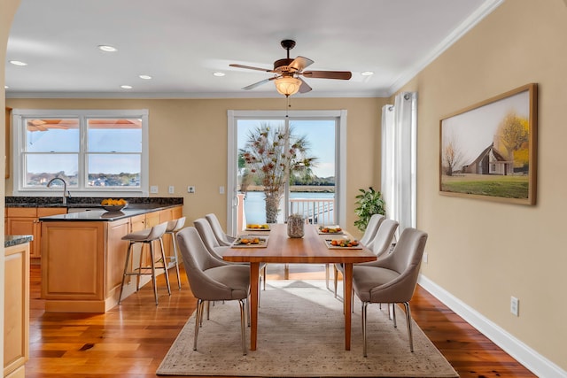 dining space with a wealth of natural light, light wood finished floors, and baseboards