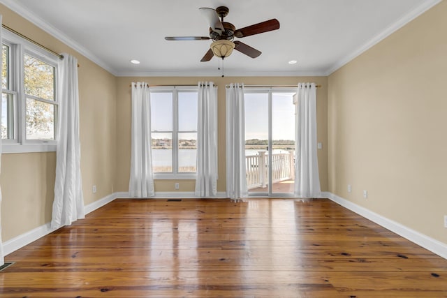 empty room with crown molding, recessed lighting, wood finished floors, and baseboards