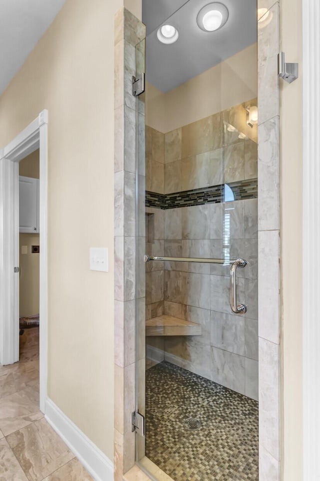 full bath with baseboards and a shower stall