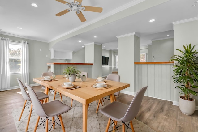 dining room featuring crown molding, baseboards, and wood finished floors