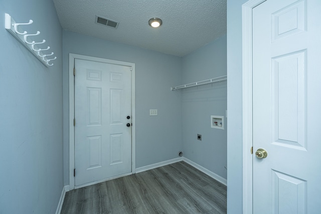 clothes washing area with electric dryer hookup, wood-type flooring, a textured ceiling, and washer hookup