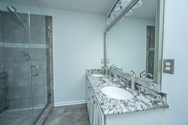 bathroom featuring a textured ceiling, vanity, tile patterned floors, and an enclosed shower