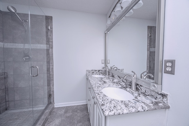 bathroom with tile patterned floors, a shower with door, vanity, and a textured ceiling