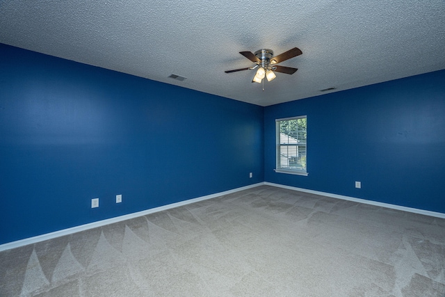 spare room featuring ceiling fan, carpet, and a textured ceiling