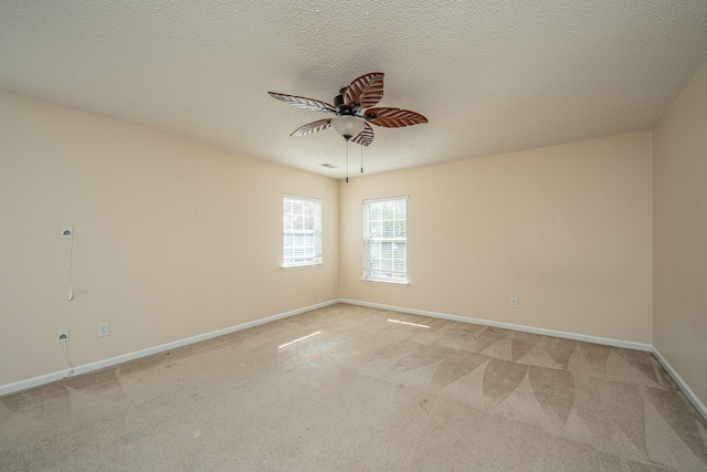 carpeted empty room with ceiling fan and a textured ceiling