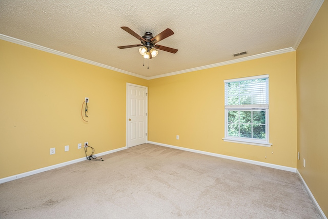 empty room featuring a textured ceiling, light colored carpet, and ornamental molding