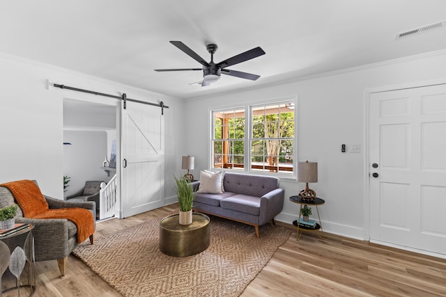 411 Berkeley Dr, Moncks Corner, SC 29461 - living area featuring a barn door, crown molding, a ceiling fan, light wood-style flooring, and baseboards