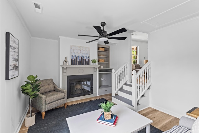 411 Berkeley Dr, Moncks Corner, SC 29461 - living area featuring attic access, a ceiling fan, wood finished floors, a glass covered fireplace, and crown molding