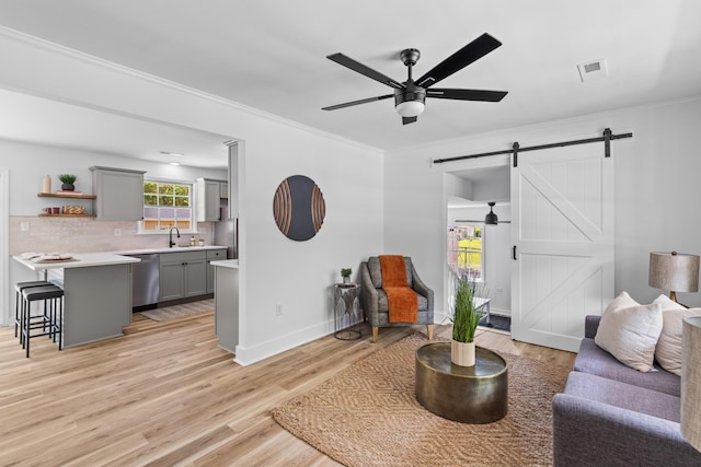 411 Berkeley Dr, Moncks Corner, SC 29461 - living area featuring a barn door, ceiling fan, light wood-style floors, ornamental molding, and baseboards