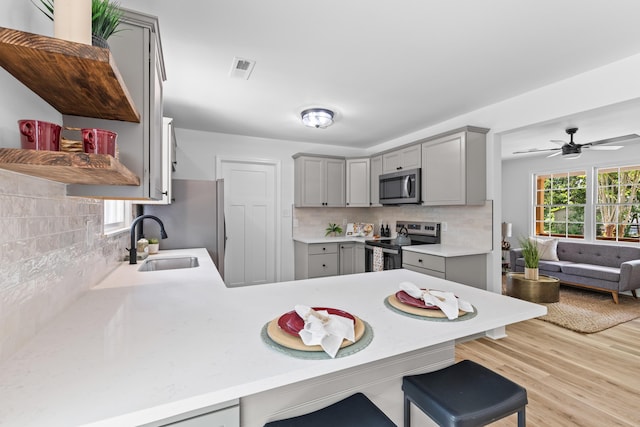 411 Berkeley Dr, Moncks Corner, SC 29461 - kitchen with gray cabinetry, stainless steel appliances, a peninsula, and a breakfast bar