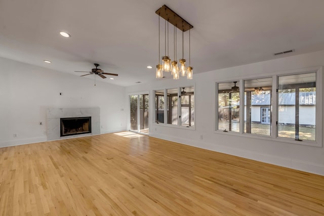 unfurnished living room featuring light hardwood / wood-style floors, a premium fireplace, and ceiling fan