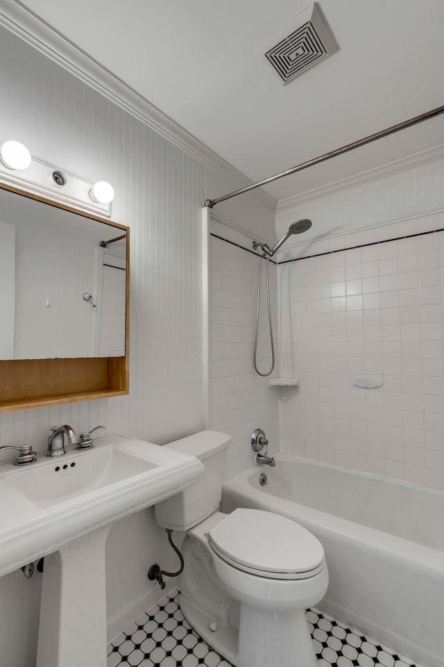 full bathroom featuring crown molding, toilet, tiled shower / bath combo, and sink