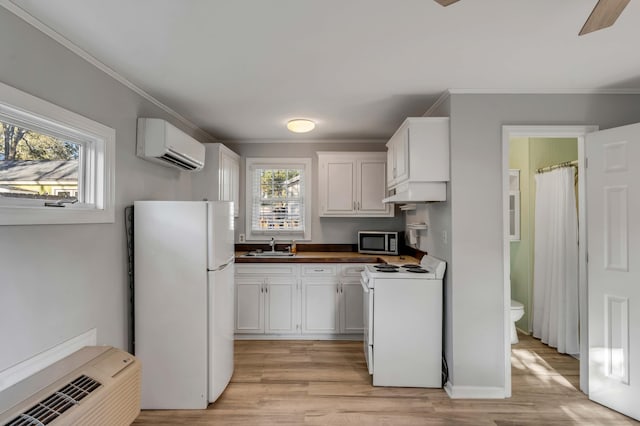 kitchen with crown molding, white appliances, a wall mounted AC, and white cabinets