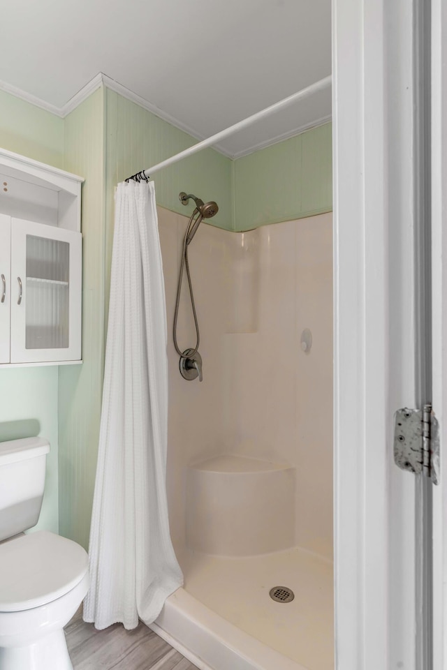 bathroom featuring crown molding, toilet, curtained shower, and hardwood / wood-style flooring