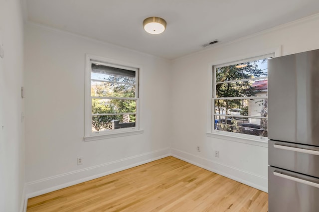 unfurnished dining area with hardwood / wood-style flooring and ornamental molding