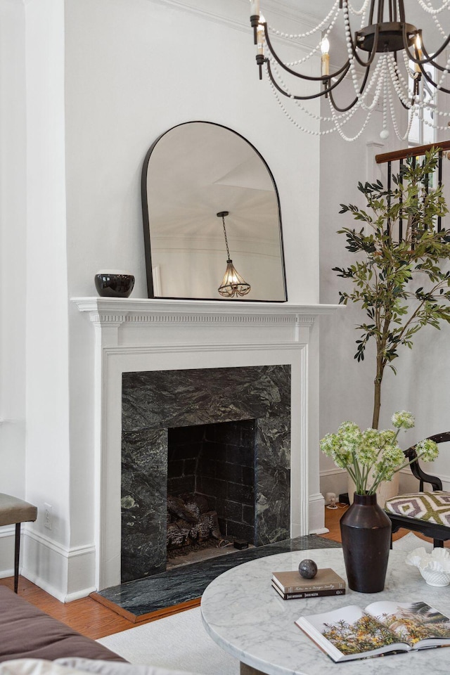 71 E Bay St, Charleston, SC 29401 - detailed view of baseboards, wood finished floors, a fireplace, and a chandelier