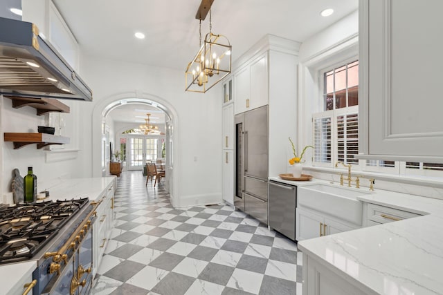 71 E Bay St, Charleston, SC 29401 - kitchen featuring appliances with stainless steel finishes, a chandelier, under cabinet range hood, arched walkways, and white cabinetry