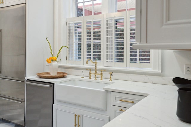 71 E Bay St, Charleston, SC 29401 - kitchen with a sink, stainless steel appliances, white cabinets, and light stone counters
